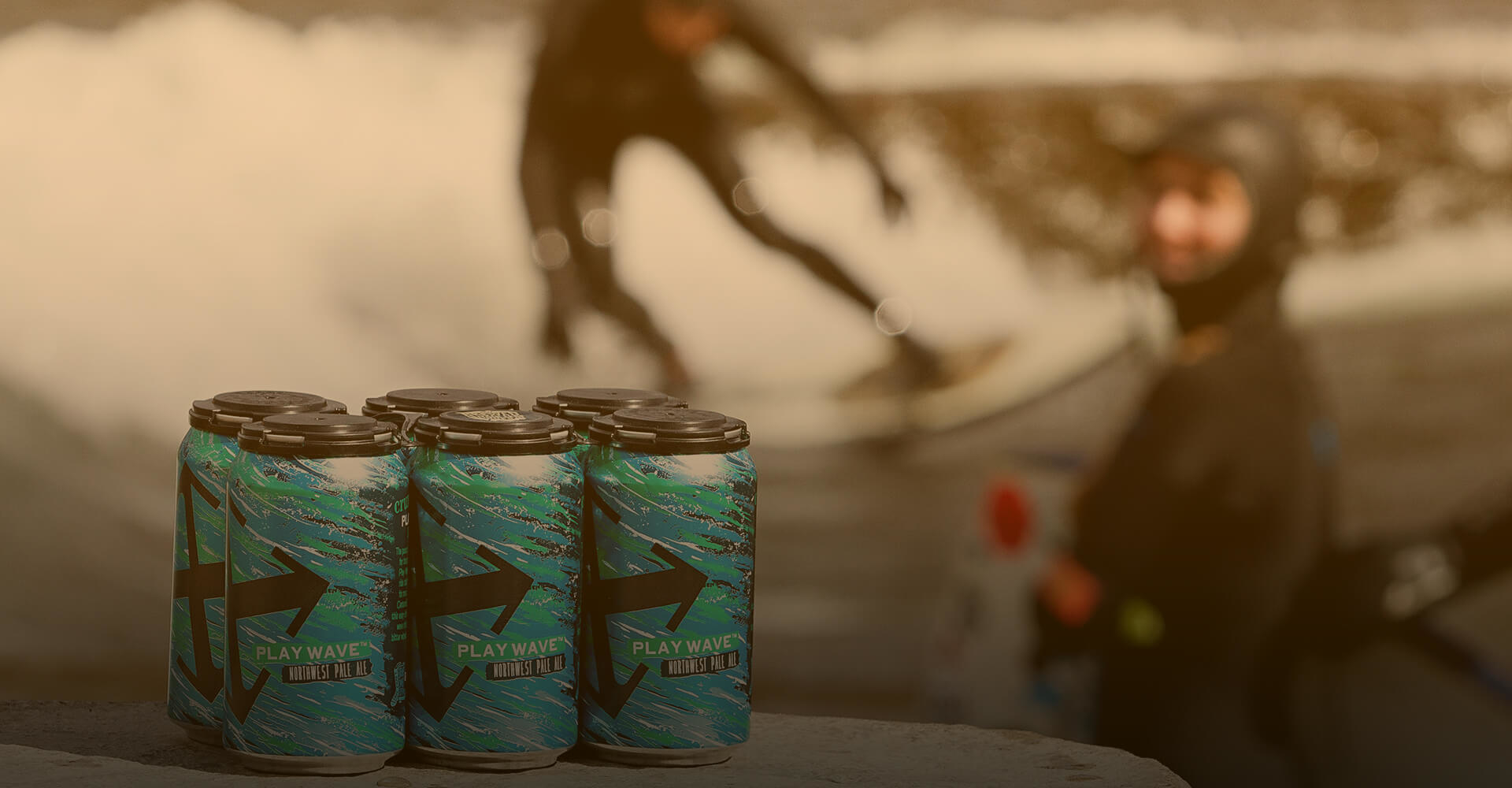 Play Wave cans with surfers in the background