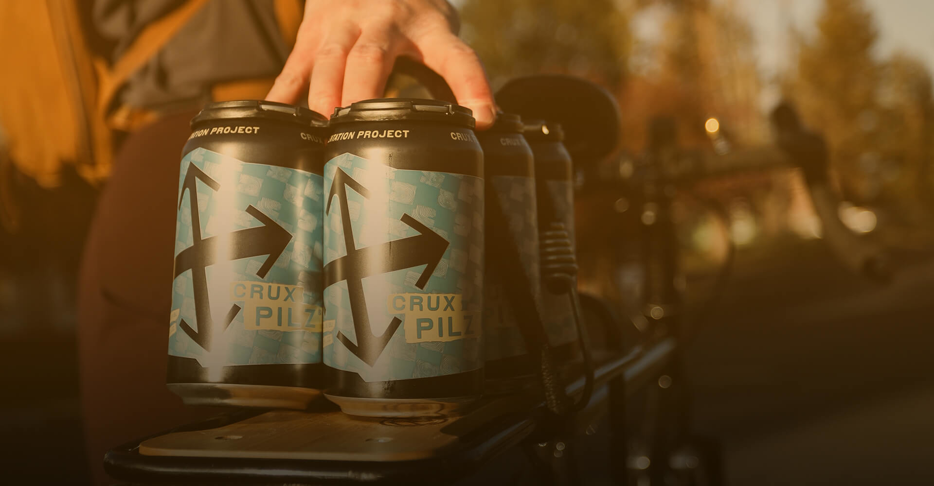 Cans of Crux Pilz on the back of a bike